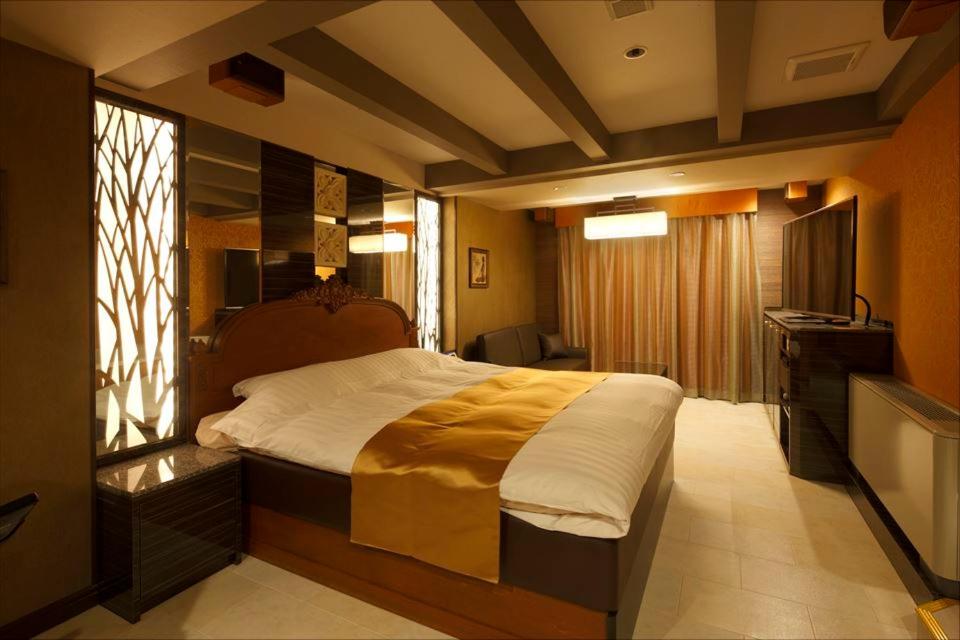 知立市知立市华尔兹情趣酒店（仅限成人）的一间卧室配有一张大床和电视