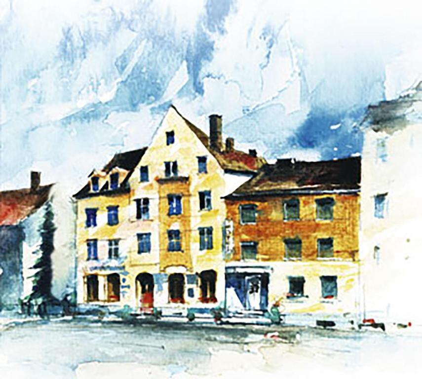 奥格斯堡法尔克奥格斯堡高德纳酒店的山前黄色建筑的画
