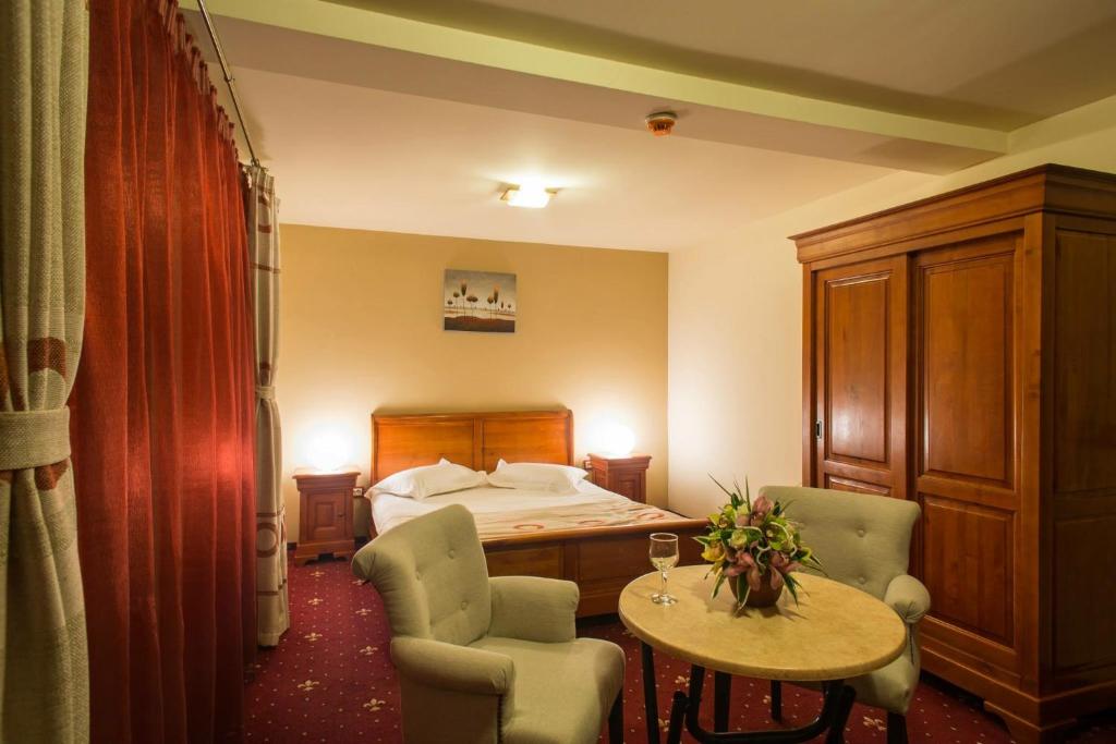 亚历山德里亚Red Hotel的酒店客房带一张床、一张桌子和椅子