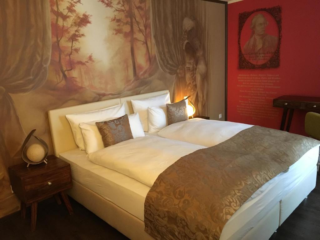 哥达Gästehaus Luise的卧室配有一张大床,墙上挂有绘画作品