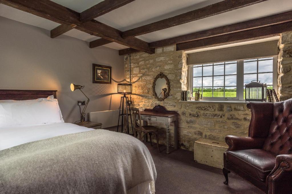 埃文河畔布拉德福韦德布鲁克庄园酒店的卧室配有床、椅子和窗户。