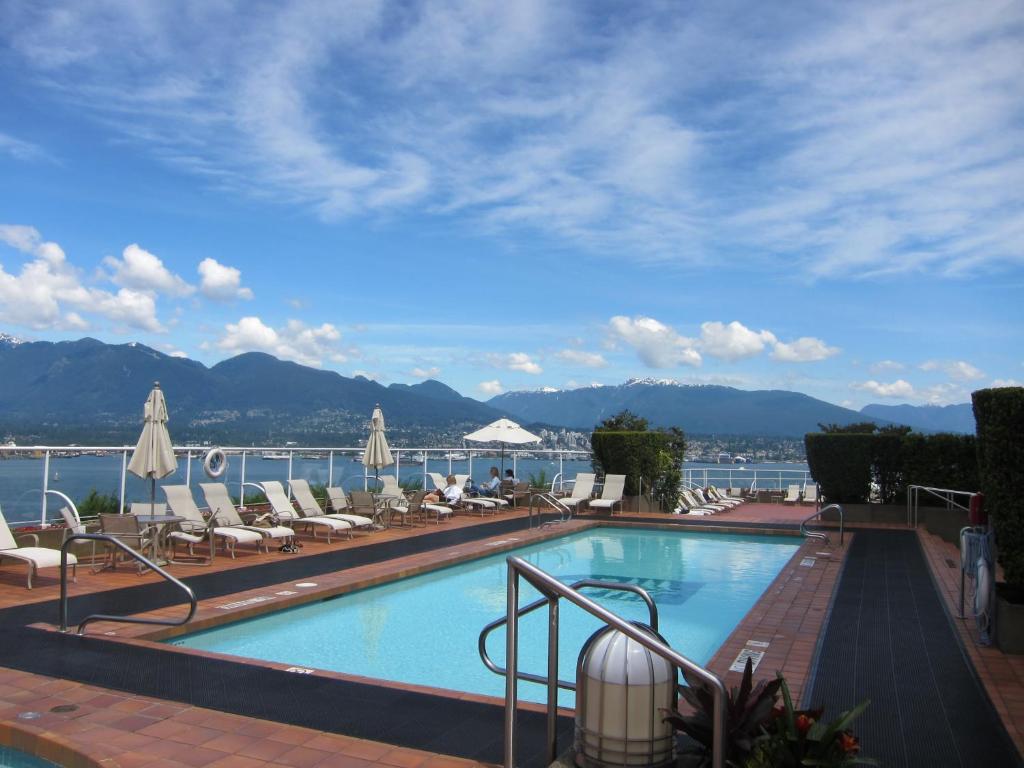 温哥华温哥华泛太平洋酒店的一个带椅子的游泳池,享有水景