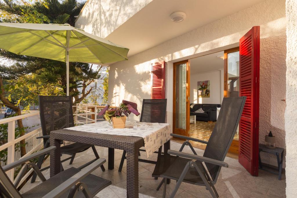 阿尔库迪亚港Villa Cactus的阳台配有桌椅和遮阳伞