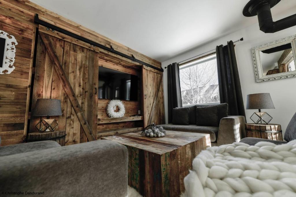拉马巴耶Le Vanilee - Les Chalets Spa Canada的一间卧室设有木墙和滑动谷仓门