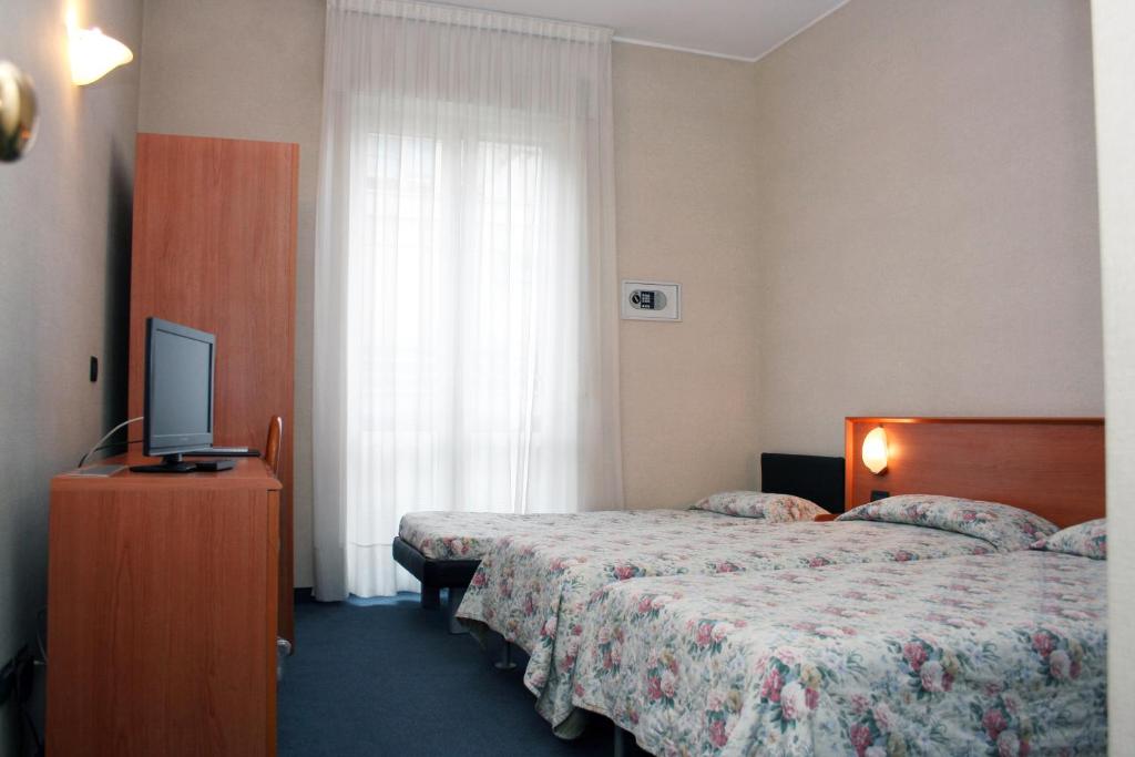 科莫尹哥帝娜酒店的酒店客房设有两张床和电视。