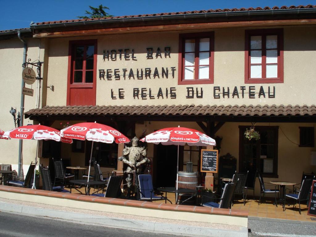 Saint-Blancard莱勒兹城堡酒店的一间带桌椅和遮阳伞的餐厅