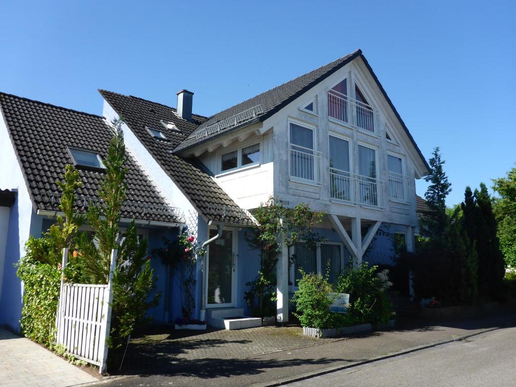 希尔波尔特施泰因Ferienwohnungen Lichtblick und Sonneck的白色的蓝色房屋,设有白色的围栏