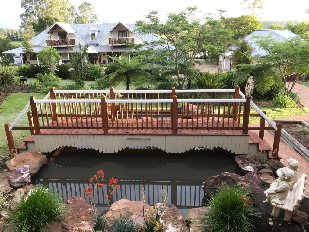 格拉夫顿克拉伦斯河住宿加早餐酒店的一座桥,在一座房子前面的池塘上