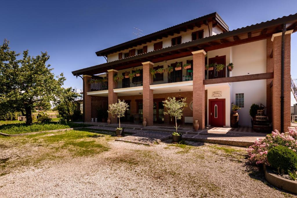 圣维托阿尔塔利亚门托诺尼斯农场酒店的一座红色门和院子的大建筑