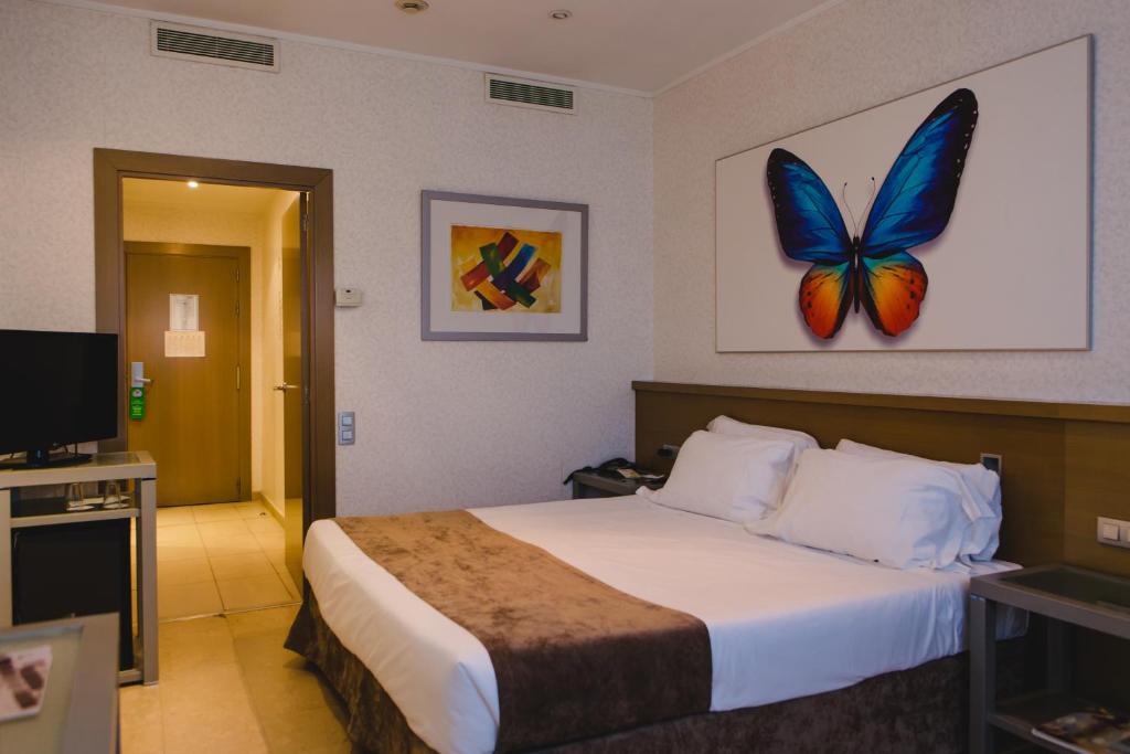 帕特纳马斯卡马雷纳酒店的酒店客房的墙上设有一张蝴蝶床。