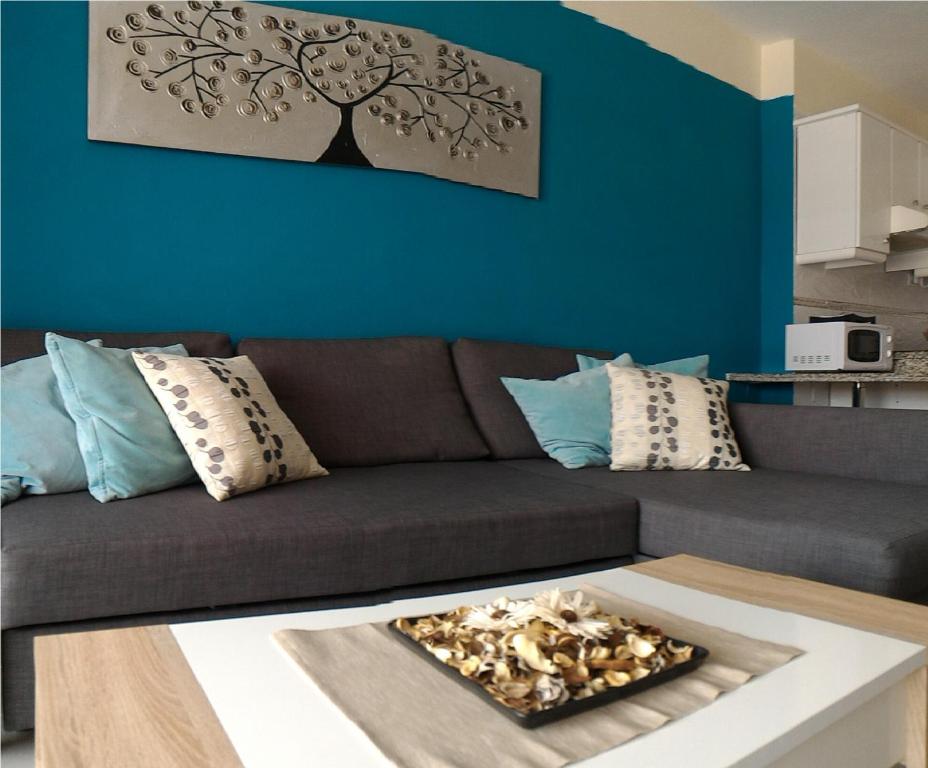 厄尔梅达诺Almi Cabezo appartamento con terrazza El Médano的客厅设有棕色沙发和蓝色的墙壁