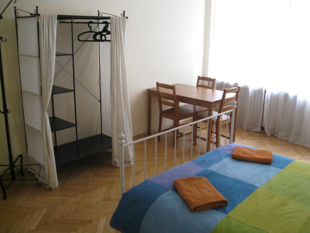 布拉格拉格泰姆酒店的卧室配有一张床和一张桌子及椅子