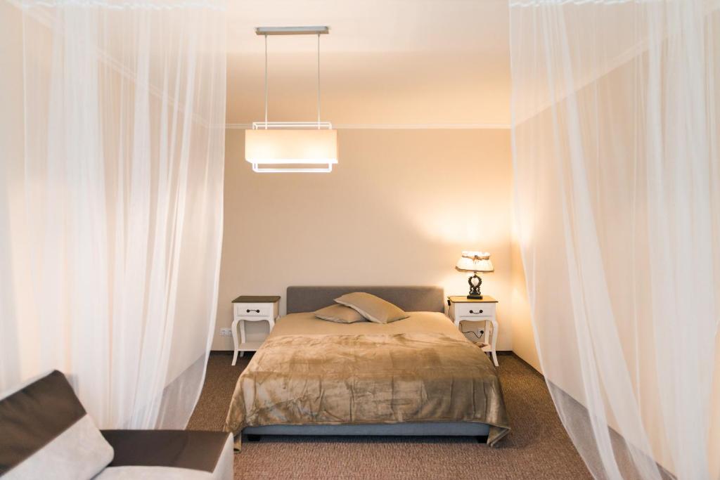 采西斯Cozy apartment in Cesis的一间卧室配有白色窗帘的床