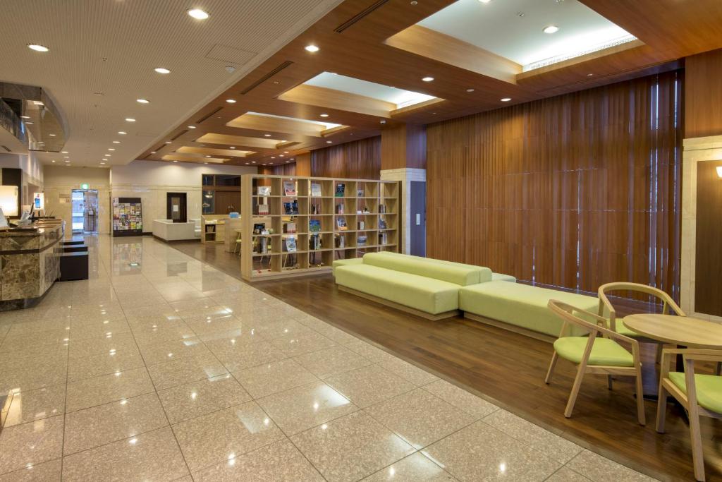 长野长野地产大酒店的图书馆配有绿色家具和桌椅