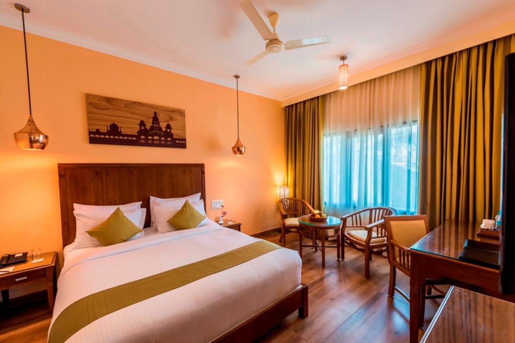 迈索尔Regenta Central Herald Mysore的配有一张床和一张书桌的酒店客房