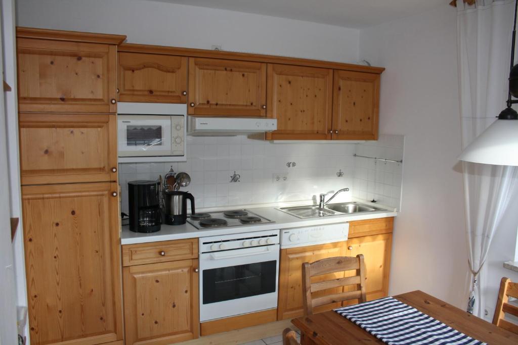 卡罗利嫩西尔Ferienwohnung Mühlenblick 3的厨房配有木制橱柜和炉灶烤箱。