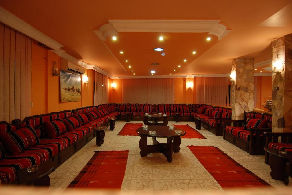 瓦迪穆萨阿尔·拉希德酒店的一间大型等候室,配有红色的椅子和桌子