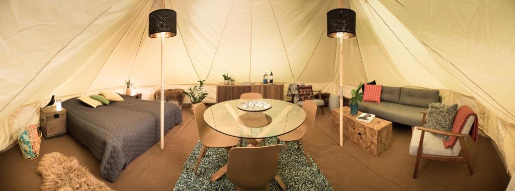 GaulverjabærCamp Boutique的帐篷内带一张床和一张桌子的房间