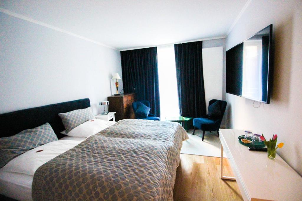 慕尼黑慕尼黑达斯克雷恩酒店的配有一张床和一张书桌的酒店客房