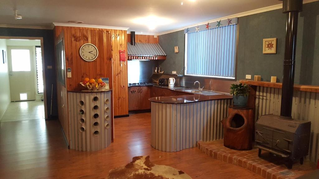 金斯科特因娜纳特度假屋的厨房配有柜台和墙上的时钟