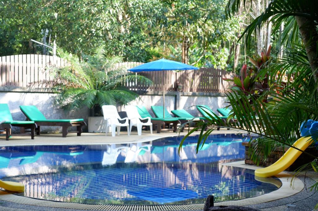 蔻立考拉城市大酒店的庭院内带椅子和滑梯的游泳池