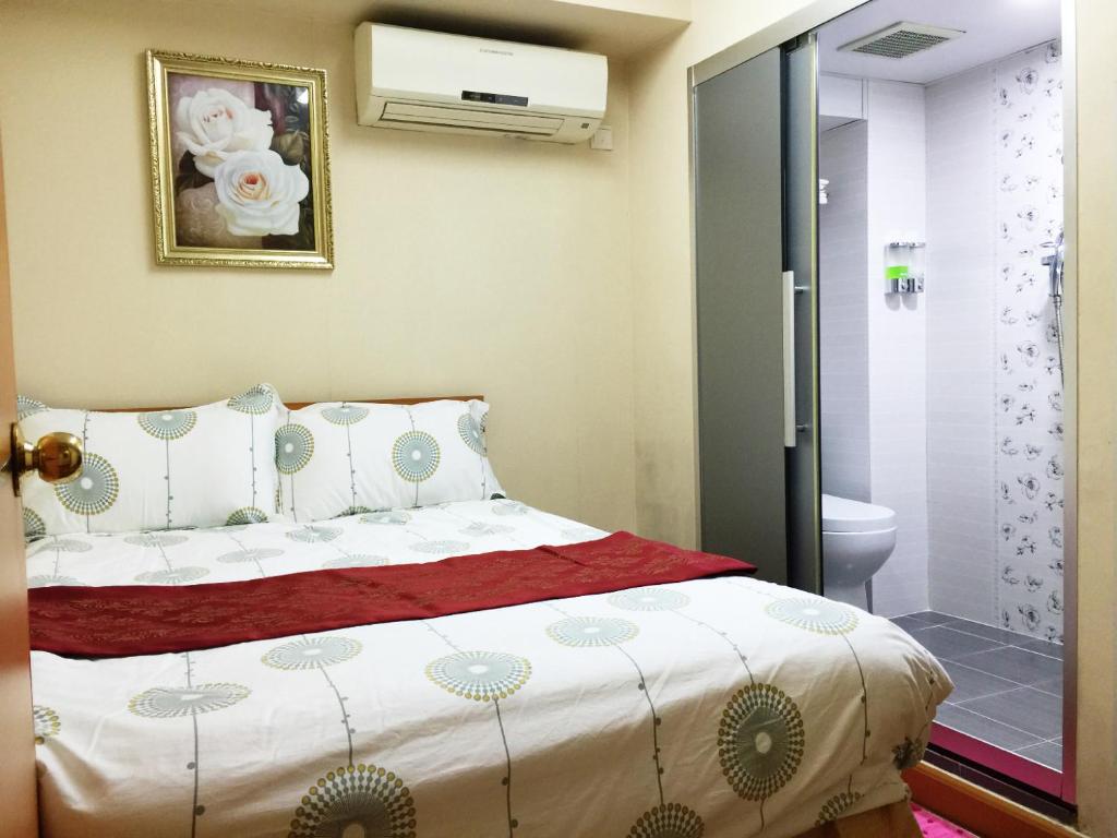 香港泰山宾馆 (喜利大厦)的一间卧室设有一张床和一间浴室。