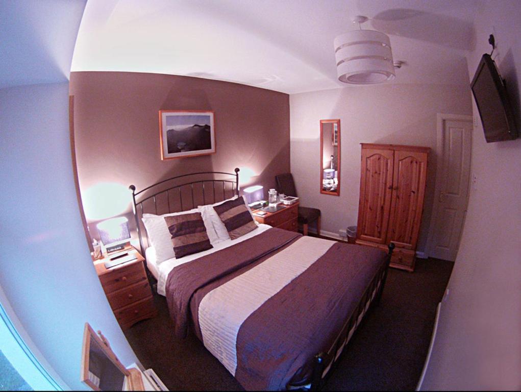 兰贝里斯格林佩里斯旅馆的一间卧室配有一张大床和一张书桌
