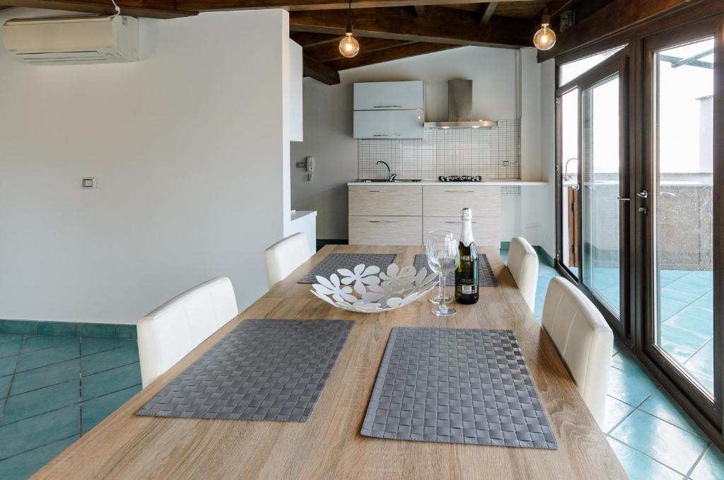 陶尔米纳Sweet Taormina Apartment的厨房配有木桌和酒杯