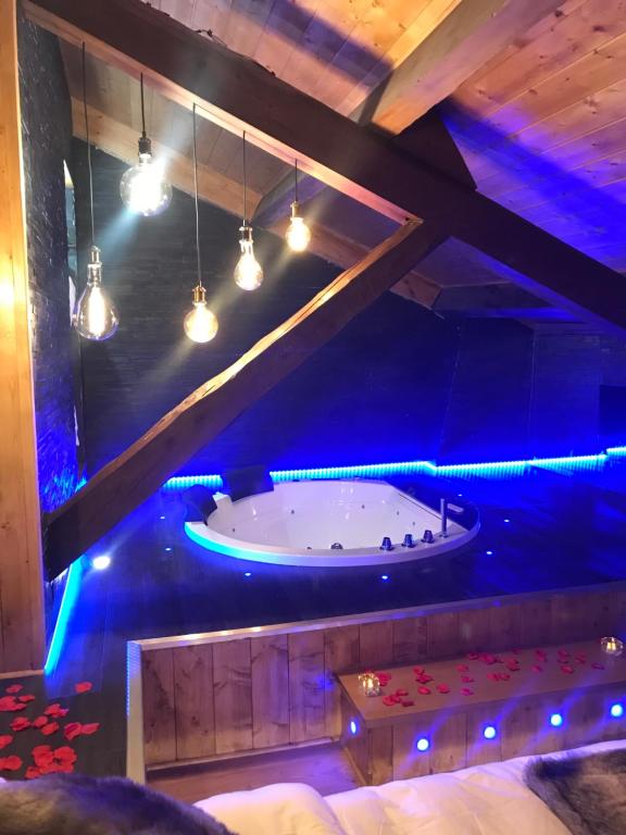 维勒班Le Chalet Loft and Spa的蓝色灯的客房内的浴缸