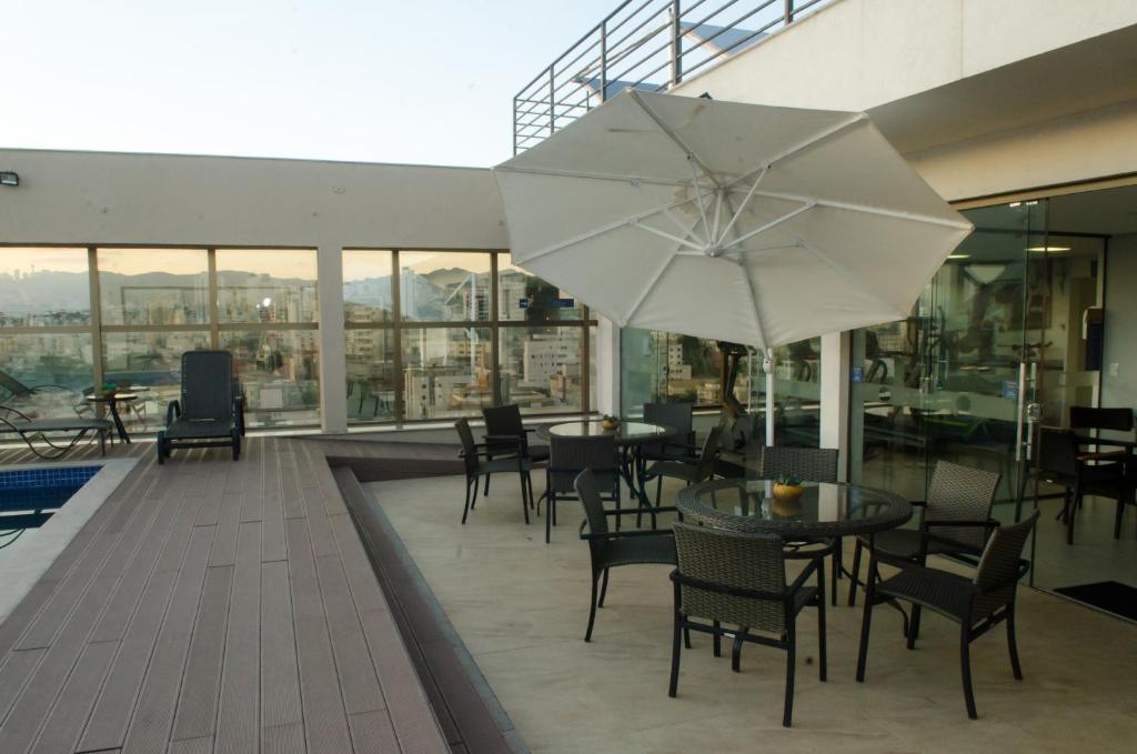 贝洛奥里藏特贝格会议中心MHB酒店的庭院配有桌椅和遮阳伞。
