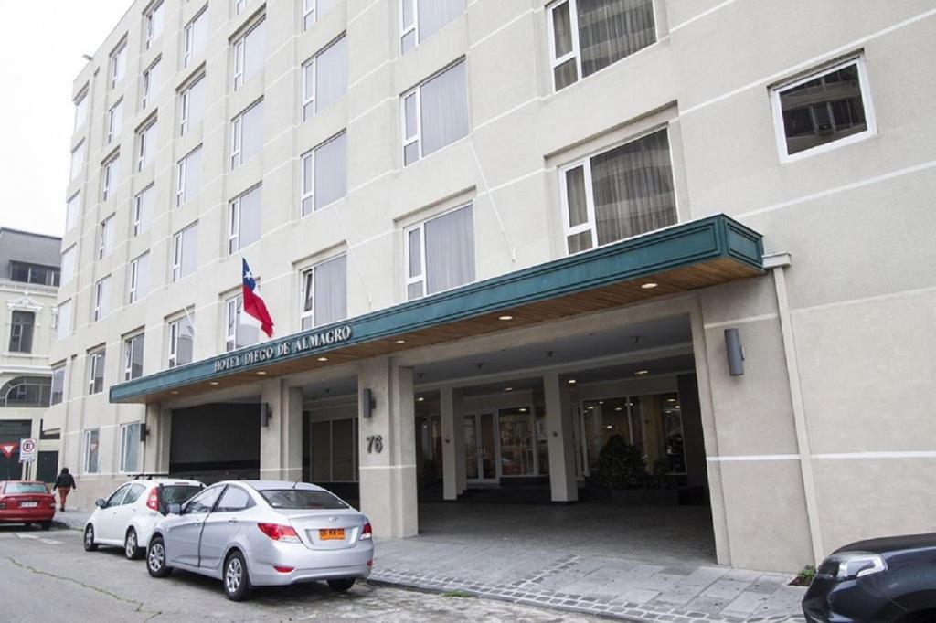 瓦尔帕莱索圣地亚哥德阿尔马格罗瓦尔帕莱索酒店的两辆汽车停在大楼前