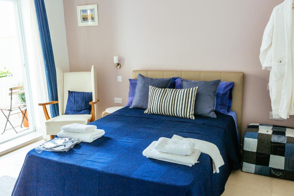 梅利哈Ghand in-Nanna B&B的一间卧室配有蓝色的床和毛巾