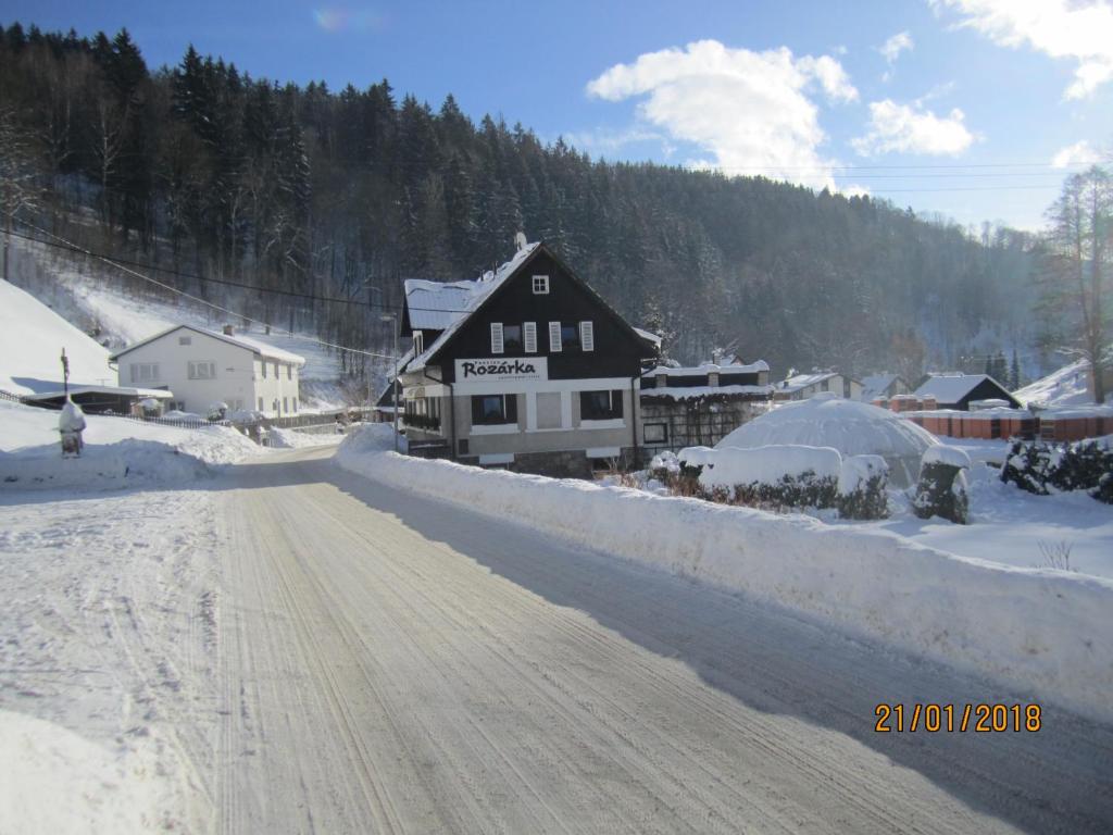 Dolni DvurChata Rozárka的建筑物前的一条有雪覆盖的道路