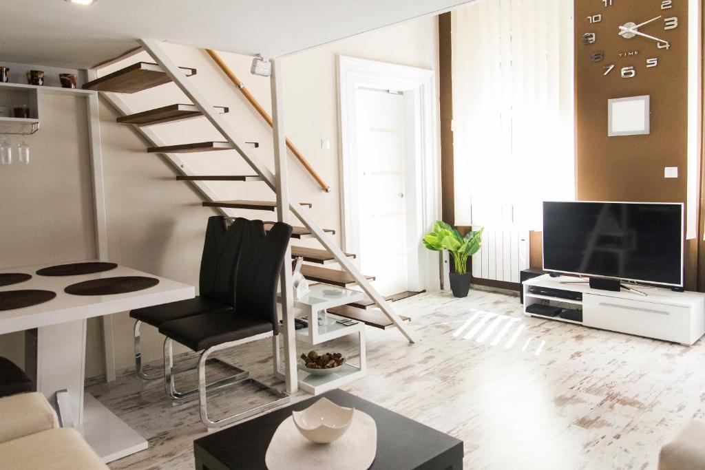 布达佩斯德宾斯基R＆R公寓的一间带楼梯和电视的客厅
