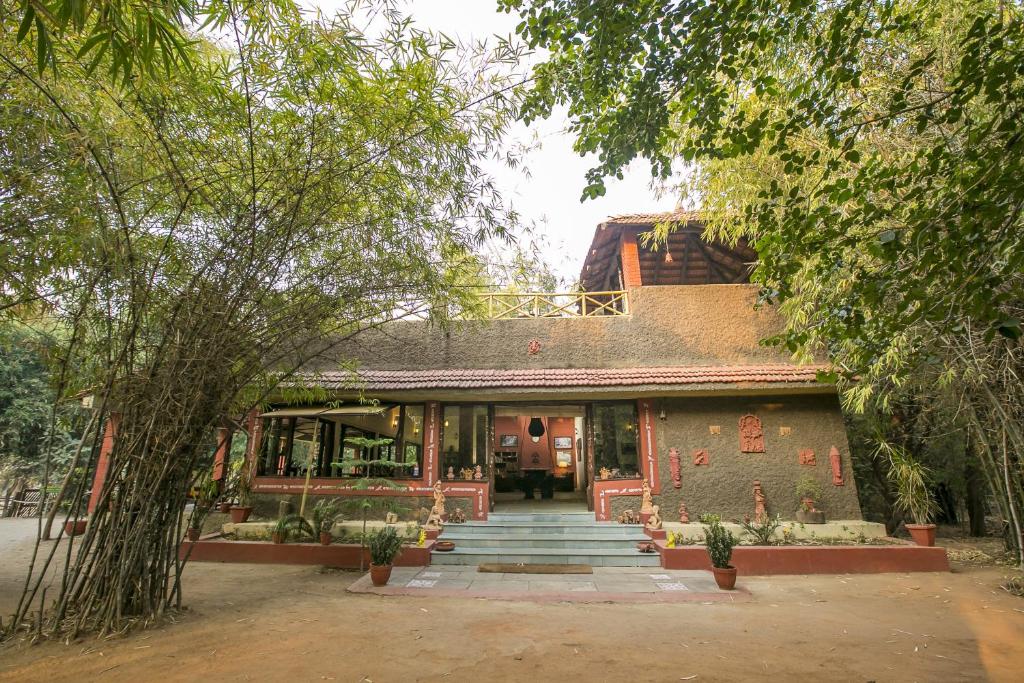 塔拉Bandhavgarh Jungle Lodge的一座带楼梯的建筑,通往树丛