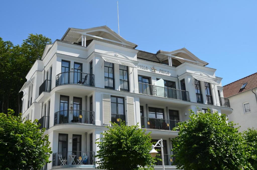 奥斯赛拜-塞林Villa "Paula" F501 - Penthouse strandnah mit Kamin und umlaufender Dachterrasse的前面有树木的白色建筑