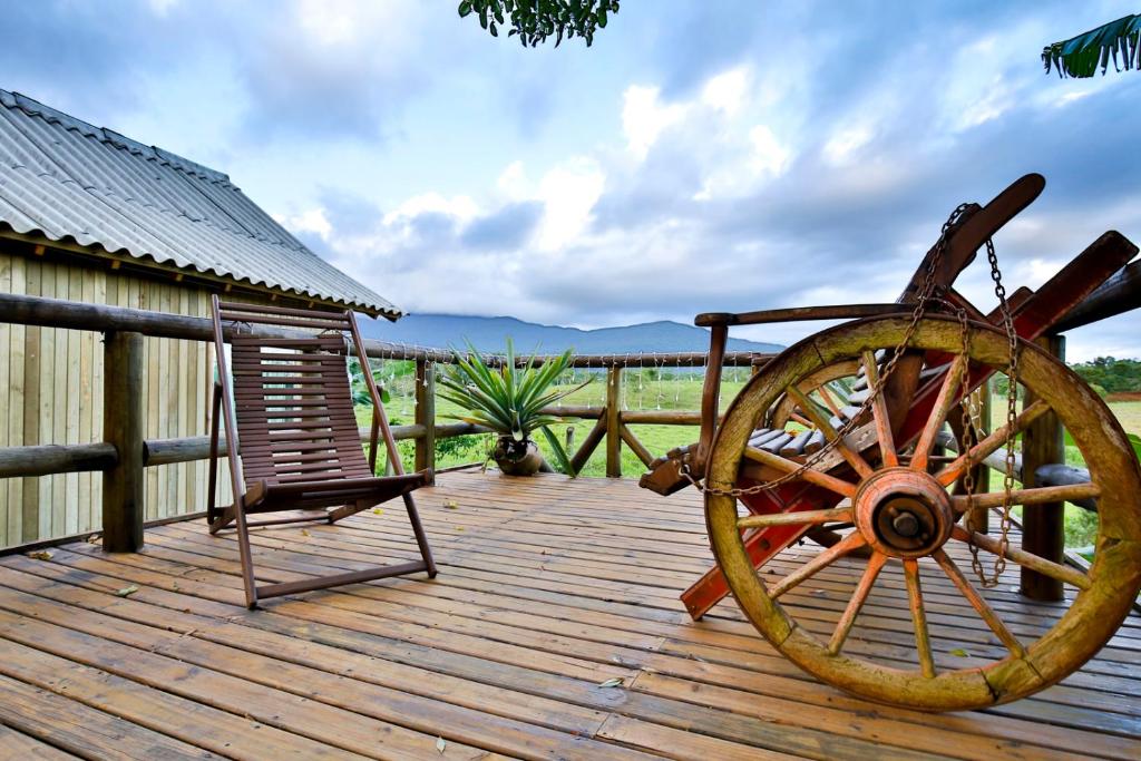 大普拉亚Pousada Vó Liane的木制甲板配有木轮和椅子