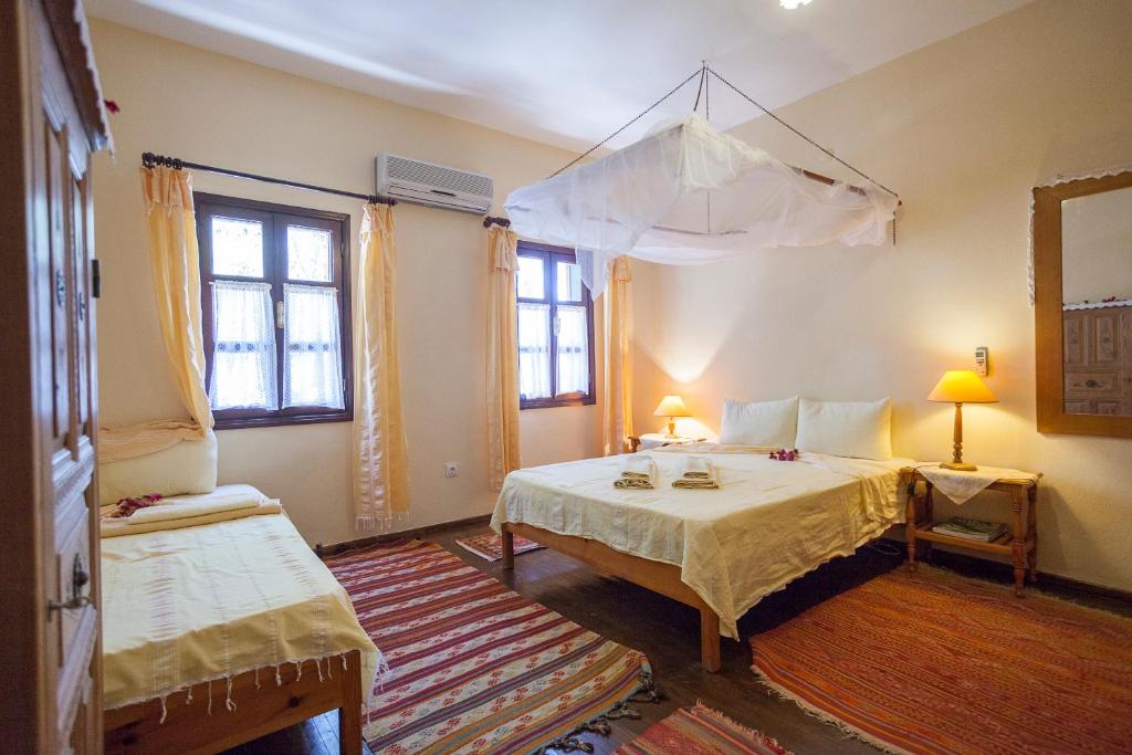 卡尔坎Kalkan Turk Evi的一间卧室配有一张带天蓬的床和两个窗户。