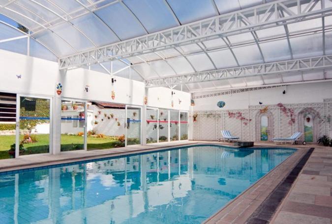 坎波斯杜若尔当庄园酒店的大楼内一个蓝色的大型游泳池