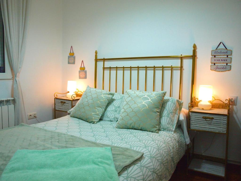 莱昂Piso Madrazo的一间卧室配有一张带枕头的床和两盏灯。