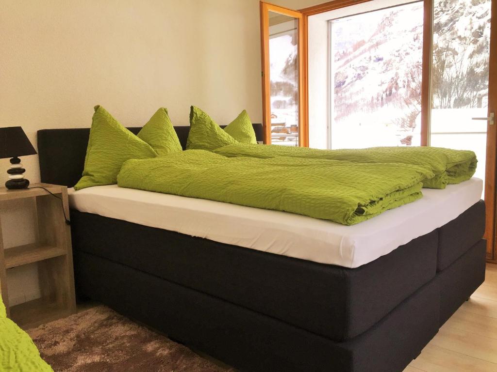 洛伊克巴德Apartments Soldanella的一张大床,上面有绿色枕头
