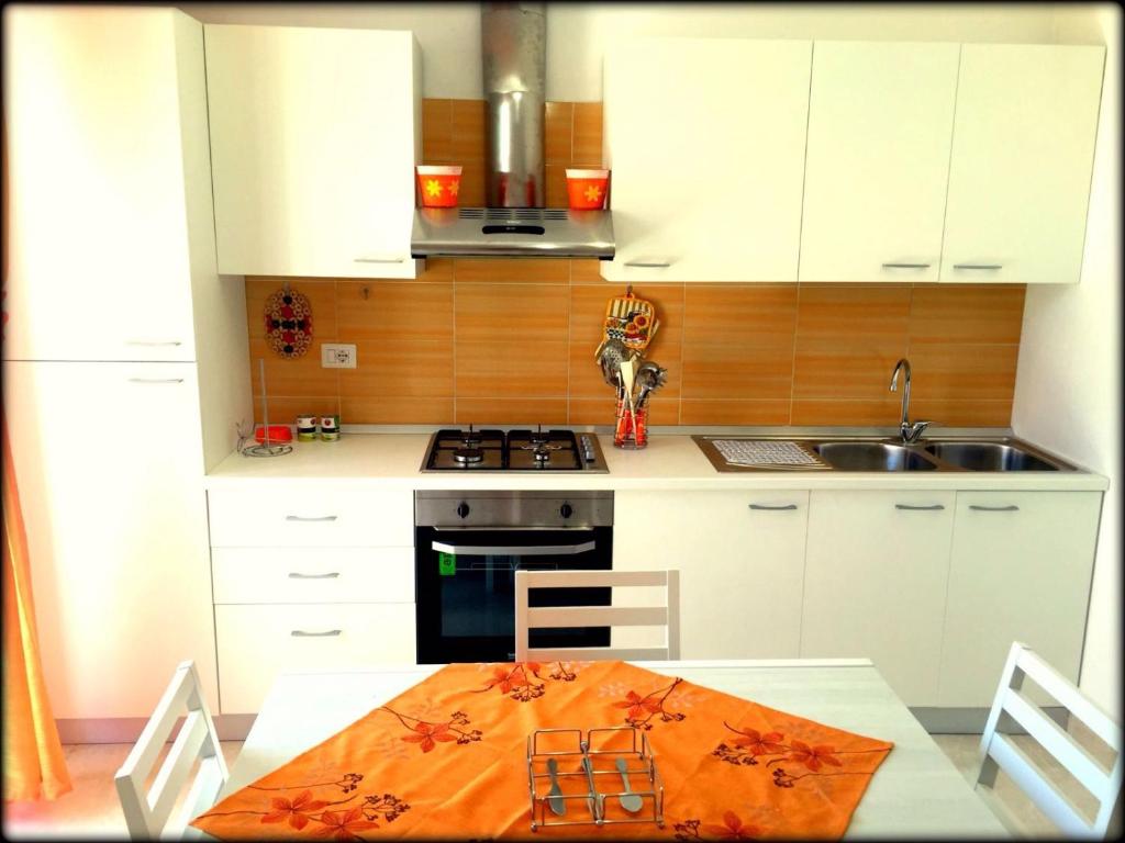 塔维亚诺Appartamento Pompea的厨房配有桌子和炉灶。 顶部烤箱