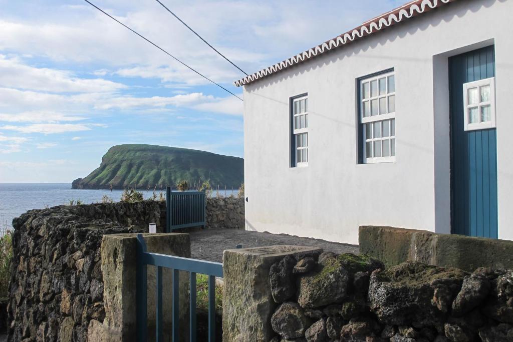 英雄港Canário do Mar - Rural Tourism的海边的白色房子,有石墙