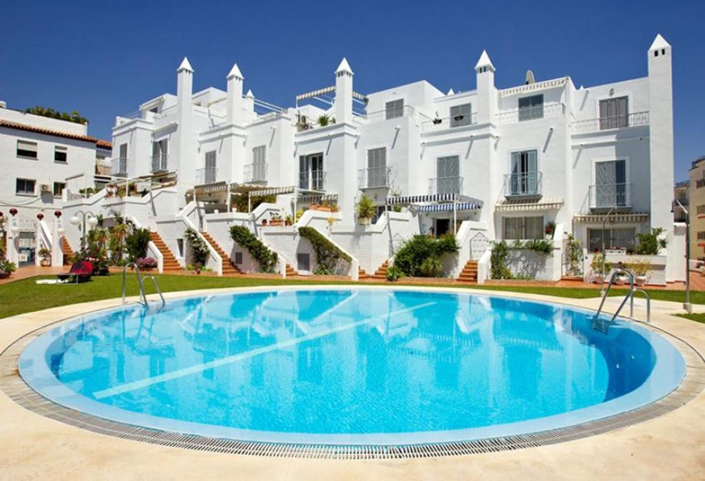 内尔哈Los Huertos de Nerja 6的一座白色大建筑前的游泳池