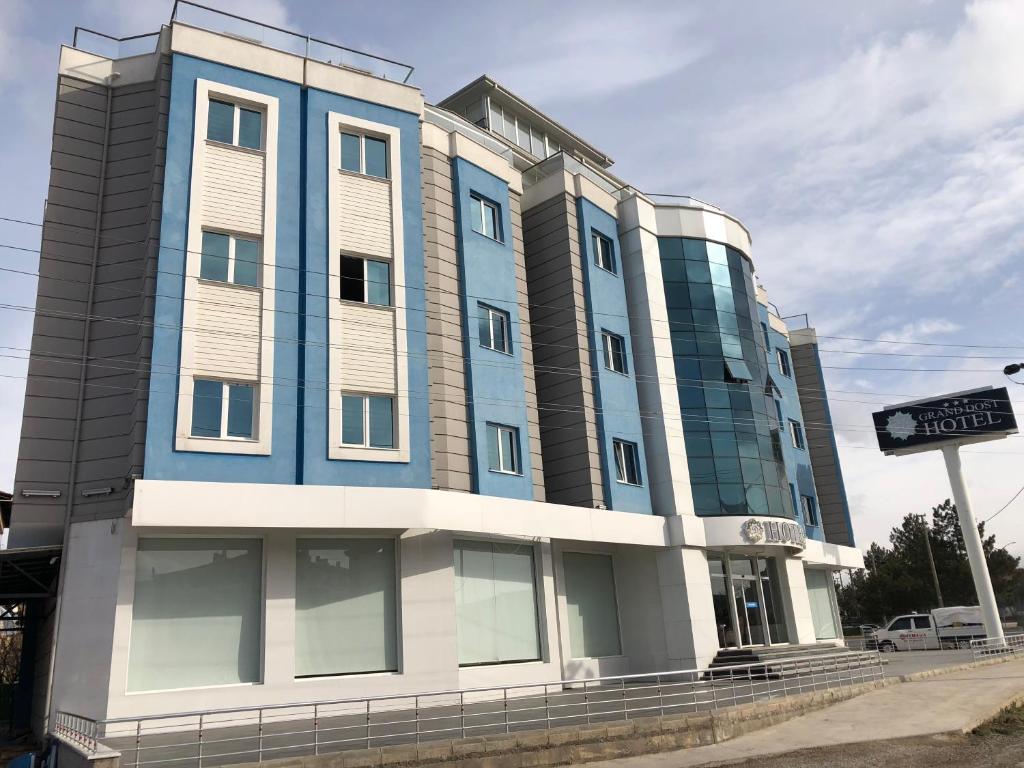 OsmancıkGrand Dost Hotel的蓝色的建筑,前面有标志