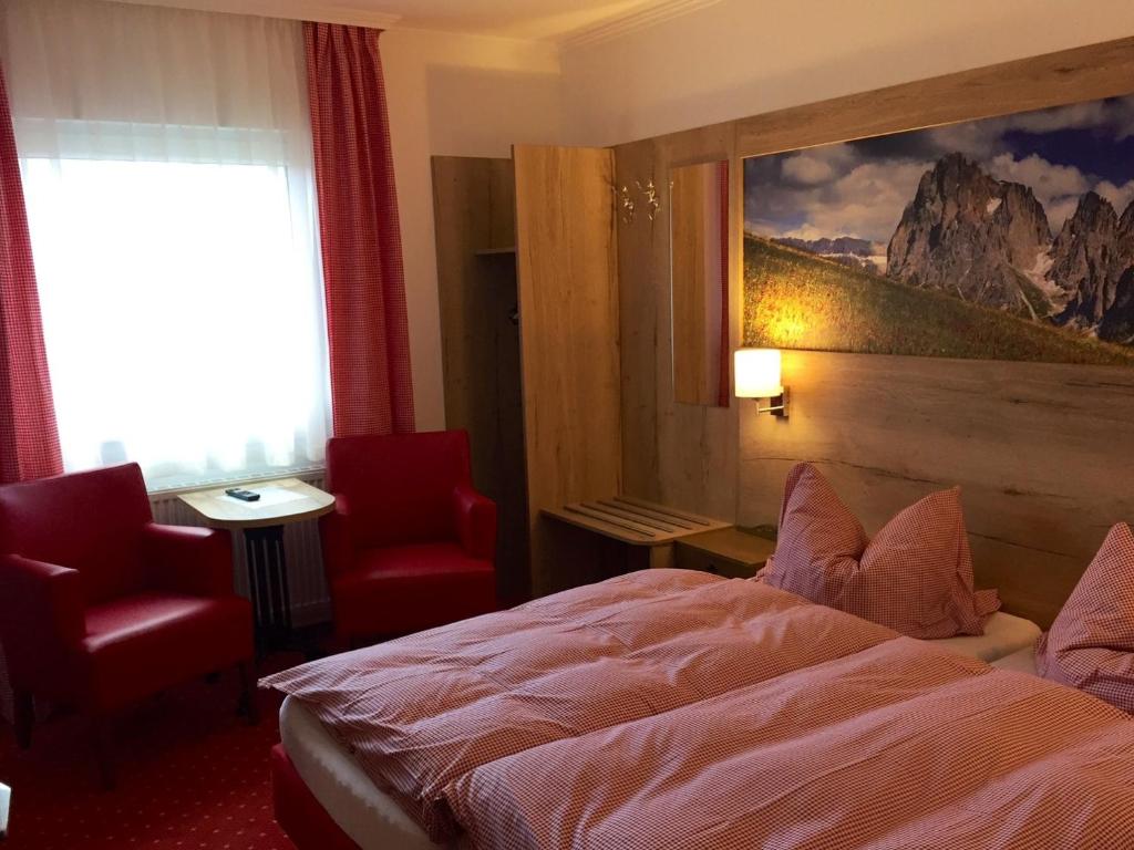 伊瑟隆Hotel Peiler Garni的酒店客房设有一张床,墙上挂有绘画作品