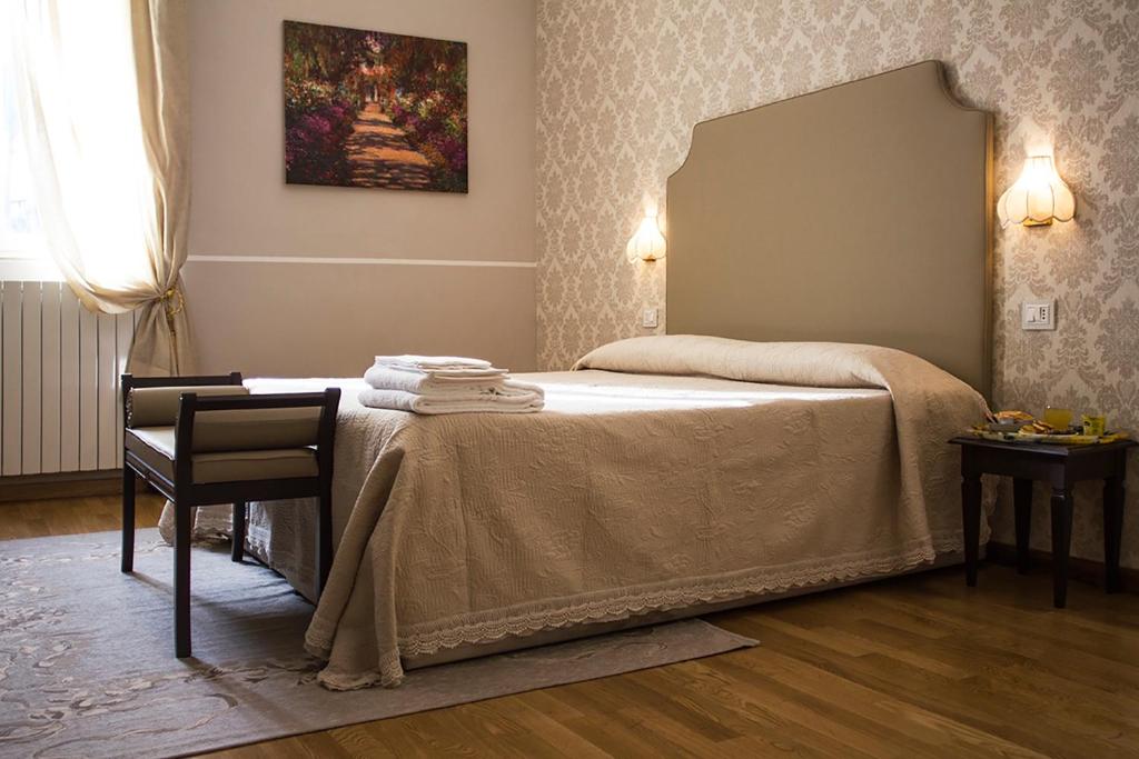 利沃诺海军酒店的一间卧室配有一张带镜子和椅子的床