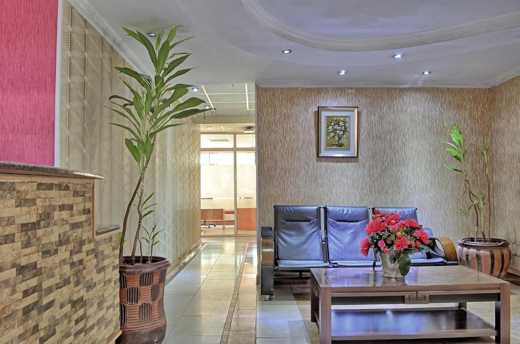 内罗毕Space International Hotel的大堂配有沙发和鲜花桌