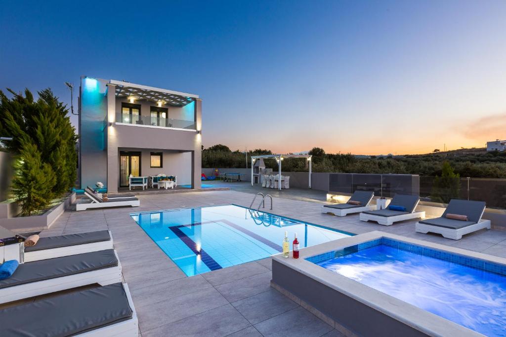 AngelianaEvangelos Villas, lavish touch, By ThinkVilla的一座带游泳池和房子的别墅