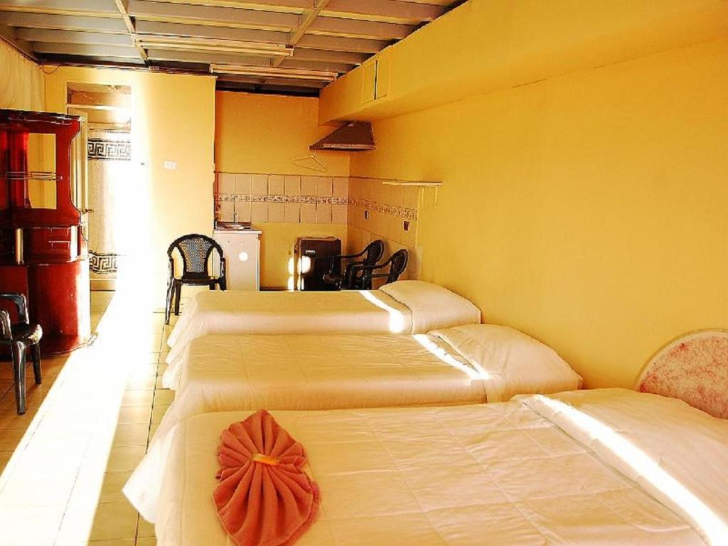 伊基克Hotel Rozal Spa Iquique的黄色墙壁客房的两张床